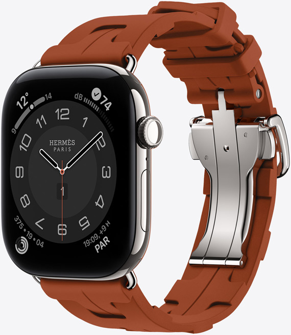 Apple Watch Hermès Series 12, cadran analogique Circulaire, (aiguilles des heures, des minutes et des secondes, complications : Météo, Bruit, anneaux Activité et heure de Paris), boîtier en titane, argent, côté droit, Digital Crown, bouton latéral, associée au bracelet Simple Tour Kilim, cuivre (marron), caoutchouc moulé, motifs géométriques entremêlés, fermoir en métal argent