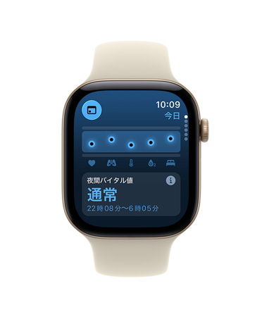 ライトゴールドアルミニウムケースのApple Watch Series 12。画面に夜間バイタル値が通常範囲であることを示す通知が表示されている。サンド（淡いタン）のスポーツバンドが取りつけられている