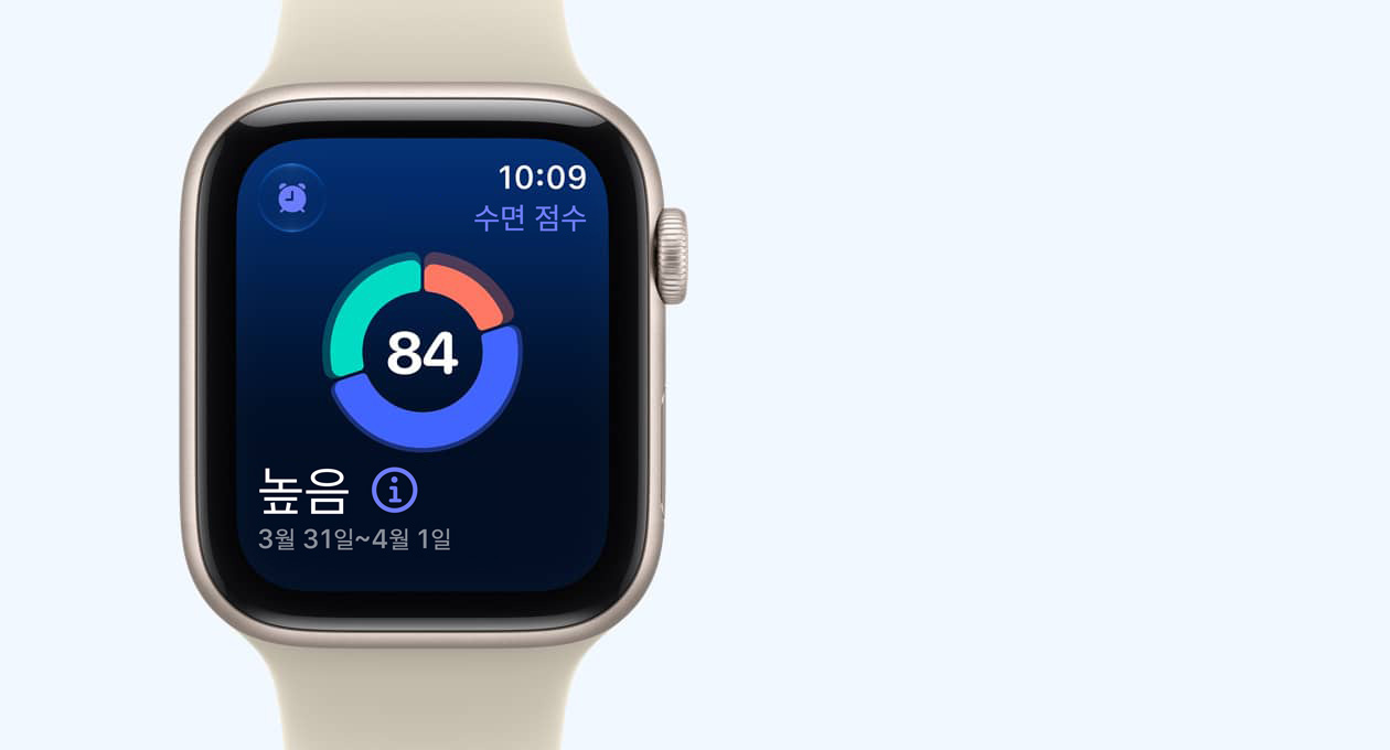 Apple Watch SE 3, 스타라이트 색상 알루미늄 케이스 및 화면에 원형 수면 점수 그래프가 표시되어 있고 오른쪽 옆면 외관에 Digital Crown 다이얼을 보여주는 모습 및 샌드 색상(연한 탠 계열)의 스포츠 밴드