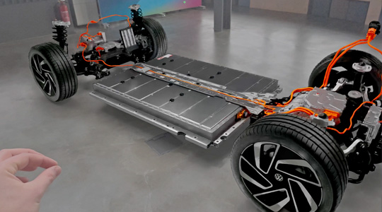 Une main faisant un geste de pincement pour interagir avec la représentation 3D d’une transmission de voiture