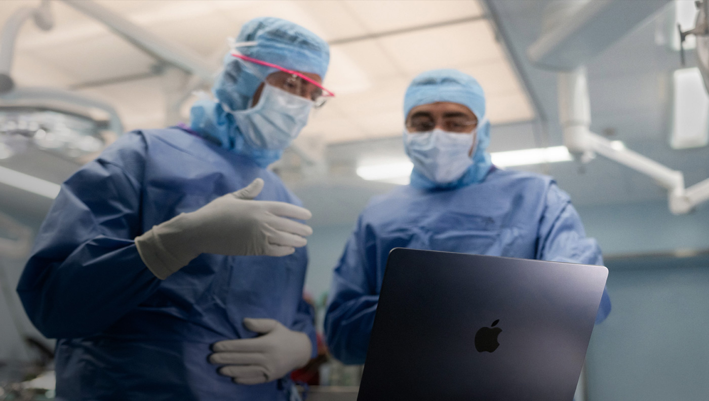 جراحان يناقشان أمراً على شاشة MacBook&nbsp;Pro في غرفة العمليات.