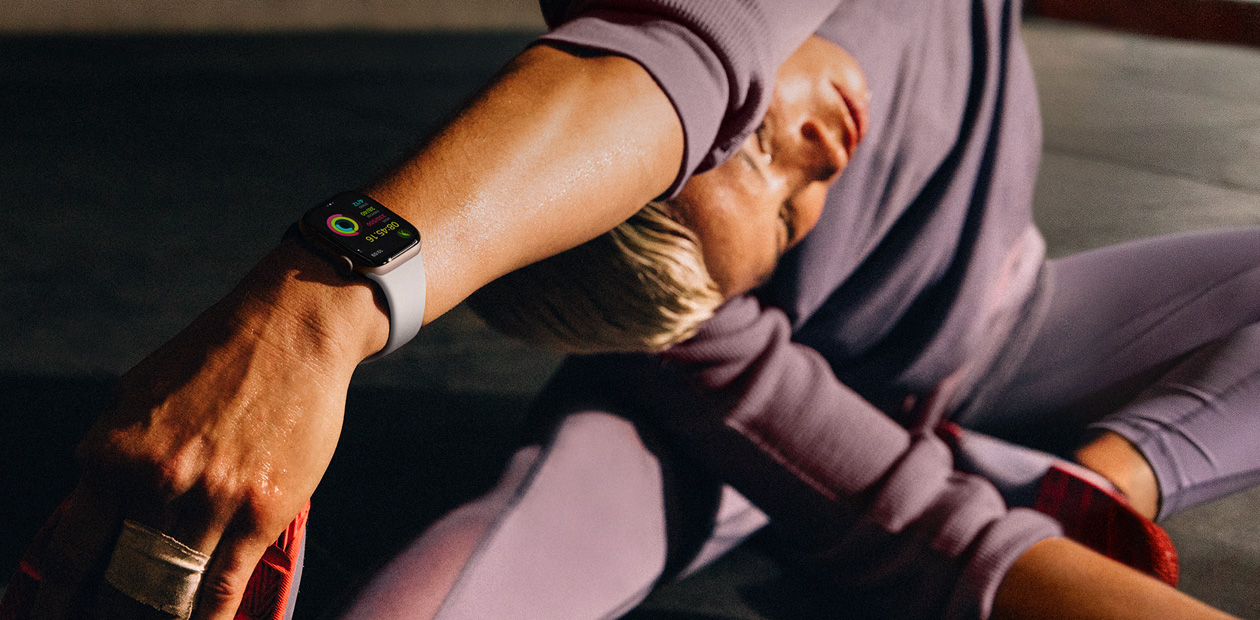 En kvinne strekker ut mens hun har på seg en Apple Watch.